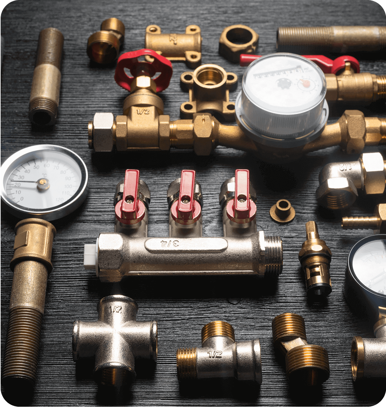 Plumbing tools and fittings on black surface.