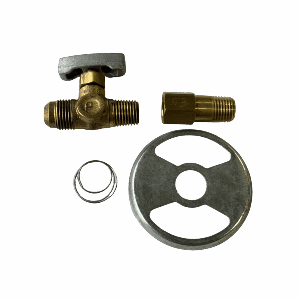 Disassembled brass valve with a handle and washer on a green surface.
