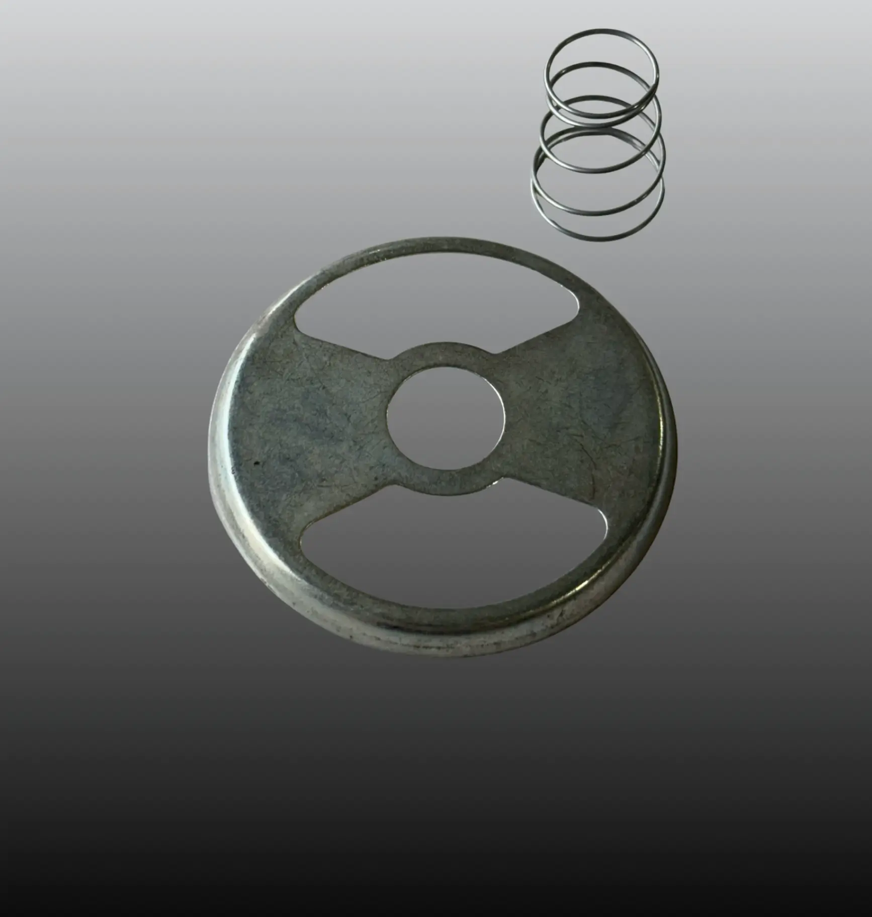 A metallic circular object with a spring on a gradient background.